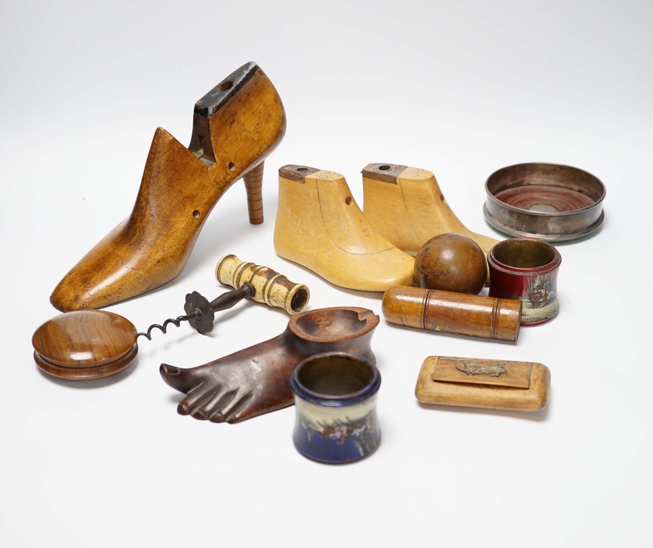 Treen: a ladies stiletto shoe last, a pair of children’s shoe lasts, a novelty foot ashtray, two lacquered napkin rings with painted Russian scenes, a bone handled cork screw etc (14)